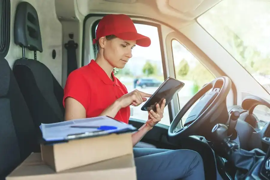 DELIVERY DRIVER Woman in Van with Tablet